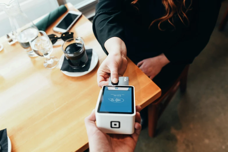 the person is holding their cell phone next to an empty wallet