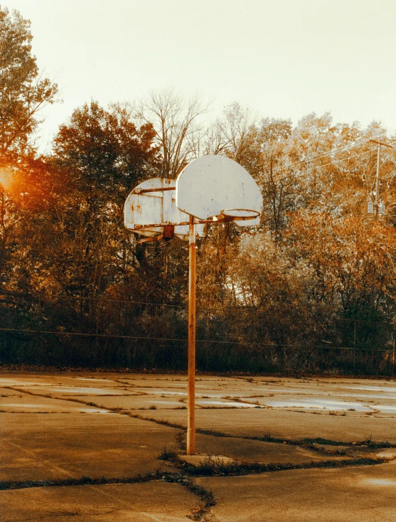 a basketball hoop and a basketball in an open lot
