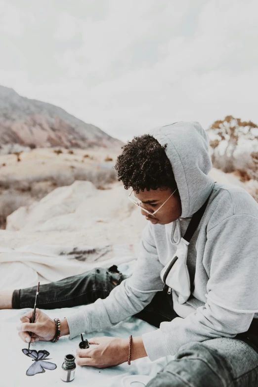 a man in hoody sitting on a snow covered mountain