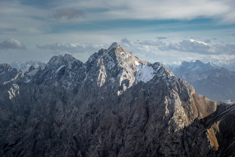 a very tall mountain in the middle of a cloudy sky