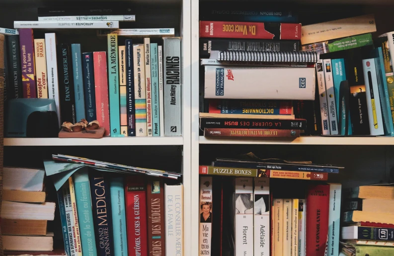 several books are displayed on the shelf with one book opened