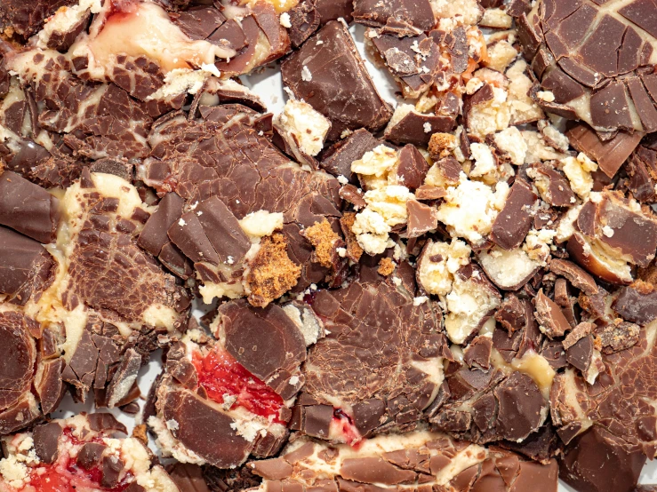 a pile of chocolate chunks and bits next to a white plate