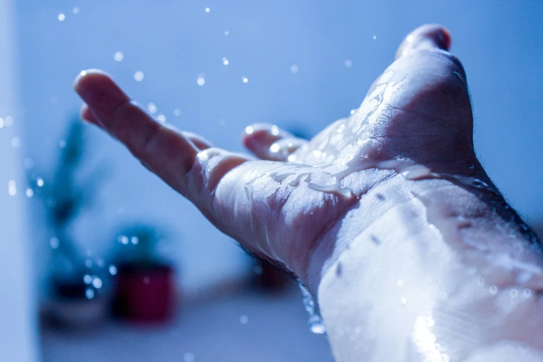 person's hand is covered with soapy water