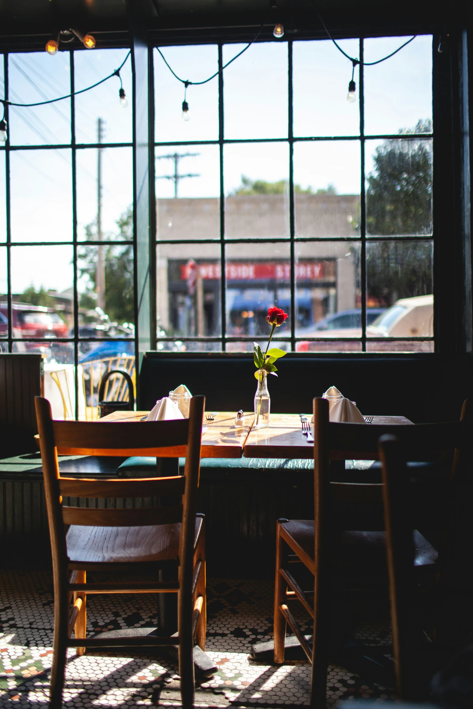 a table with chairs next to a window with a view of a street