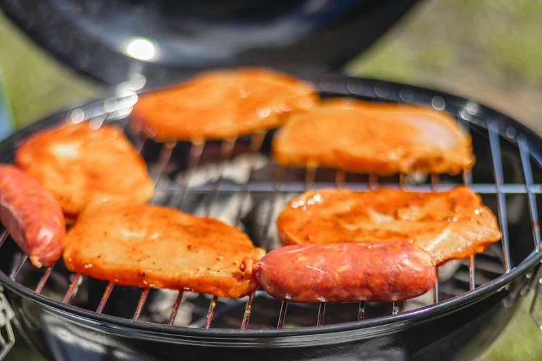  dogs and hamburgers being cooked on the grill