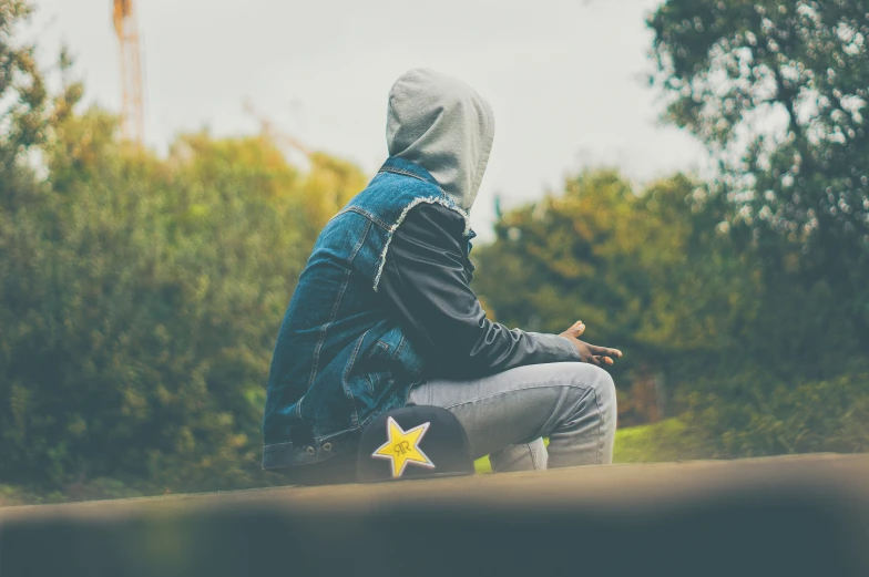 a person sitting on the ground with their hand out in front of them