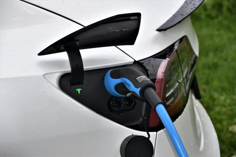 a car with an electric fuel can hooked up to a charging charger