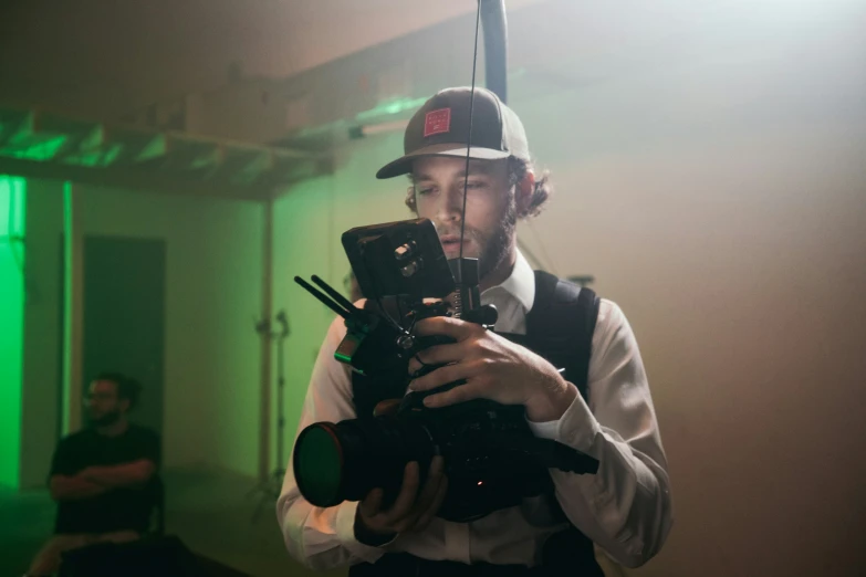 a man wearing a hat while taking a po with a camera