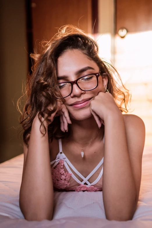 a woman with glasses laying on her bed