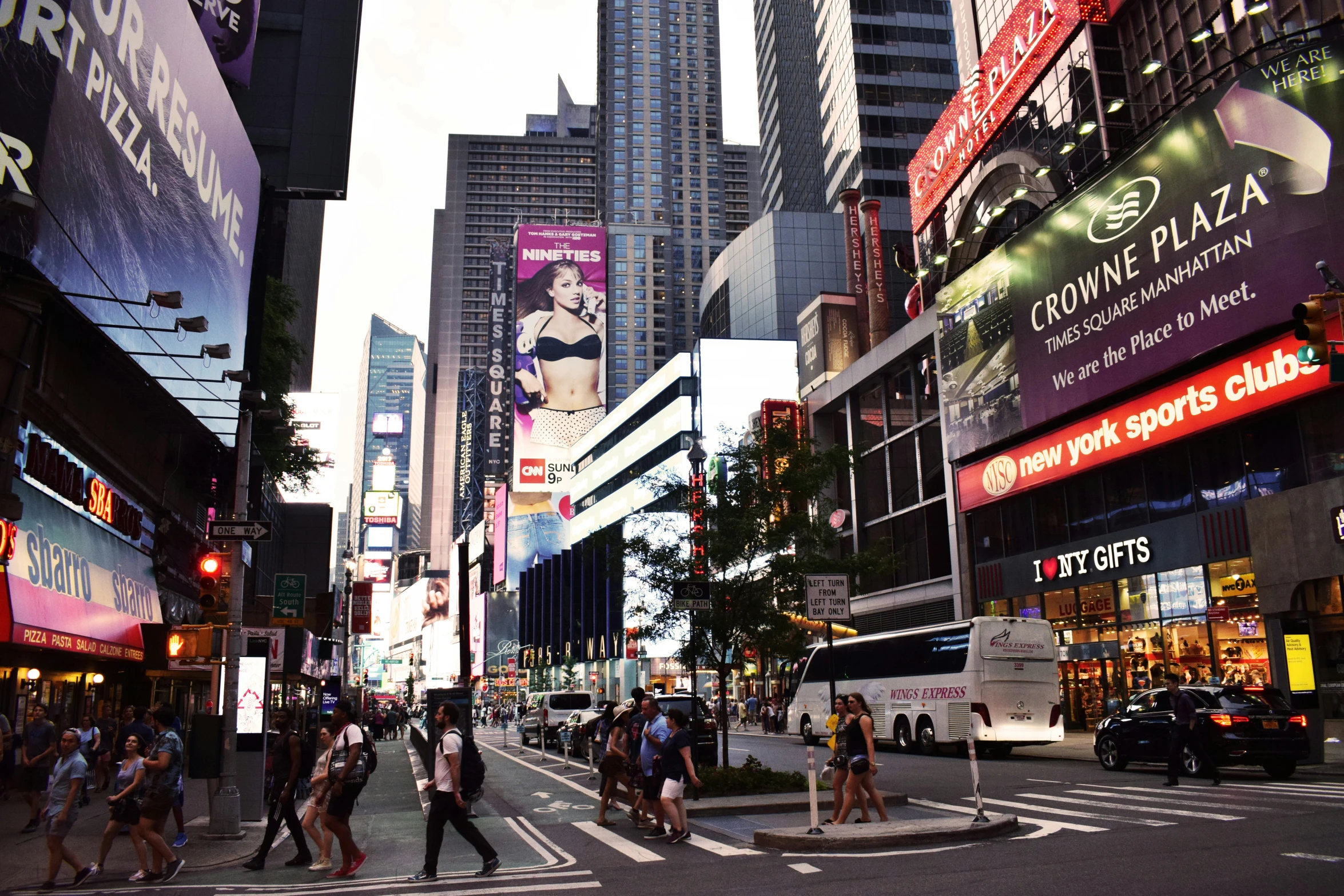 a street with cars, pedestrians and tall buildings