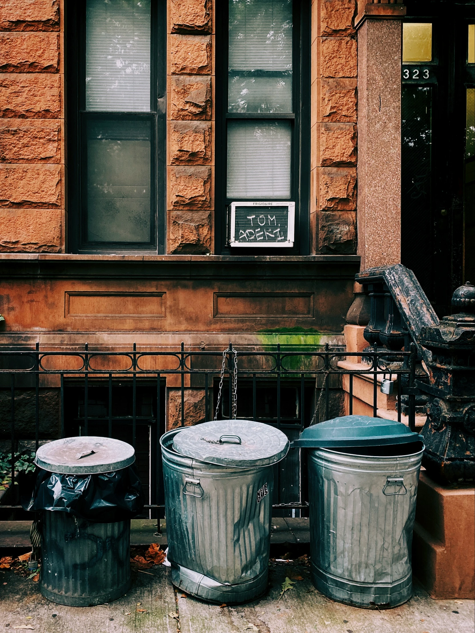 trash cans lined up in front of a building