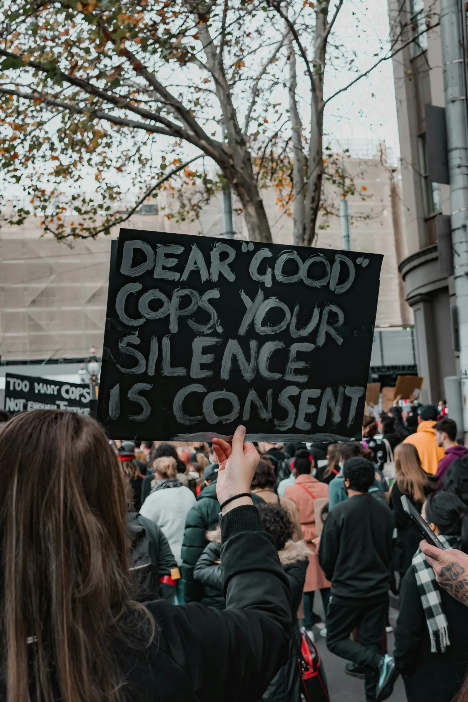 a woman holding a sign that says dear god copies your side