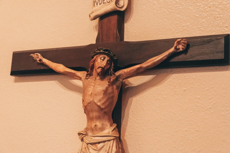 a statue of jesus on the cross with his hands together