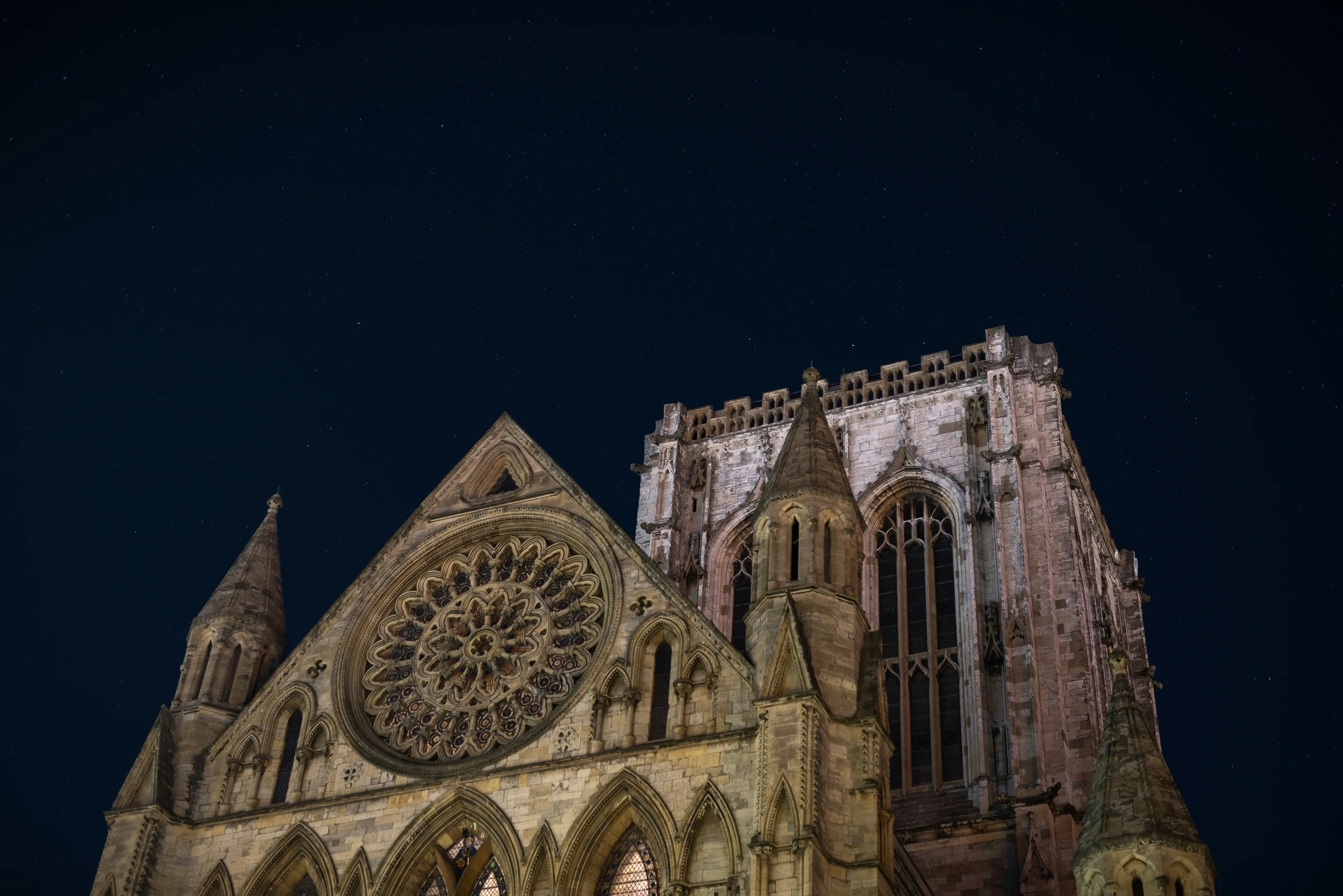 an ancient cathedral lit up at night under the starry sky