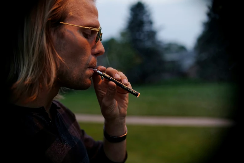 a man smoking a cigarette in the park