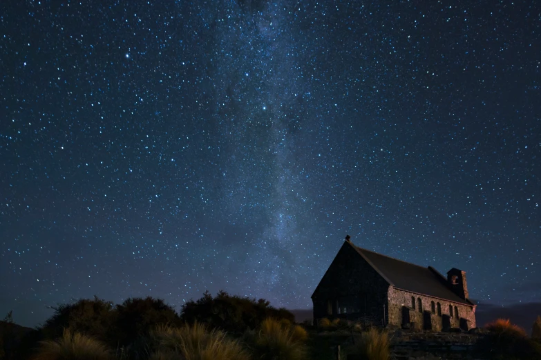 an old church is at night with a lot of stars