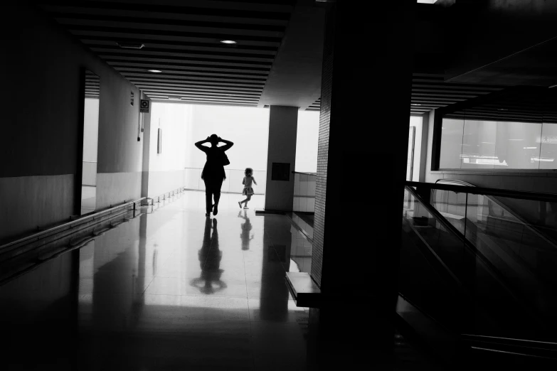 the silhouette of a person walking in a dark hallway