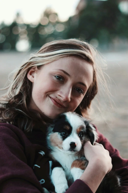a young woman smiles while holding a small dog