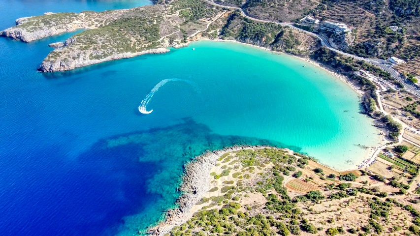 an aerial s of a boat in the middle of a blue lagoon