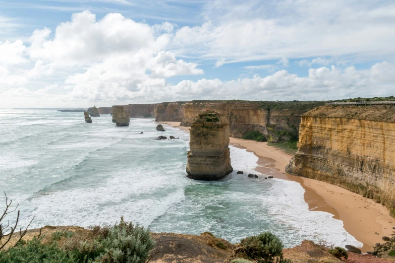 the ocean and shore along a rocky cliff face