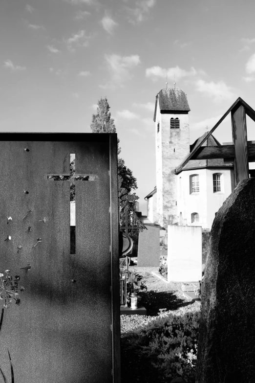 black and white pograph of the front of a building with a cross on it