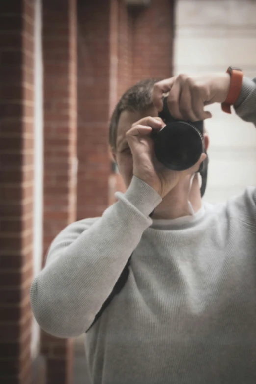 a man holds a mug while taking a selfie