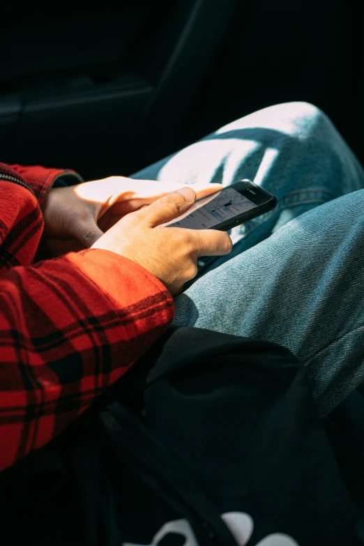 person sitting in a car using a cell phone