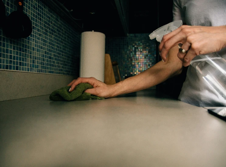 a lady wiping the cloth on top of the counter