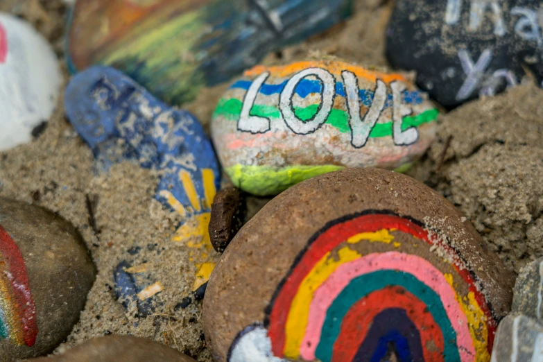 an assortment of painted rocks sitting on the ground