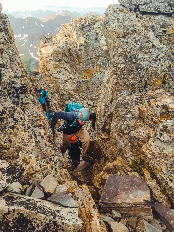 someone climbing on rocks with the ground in view