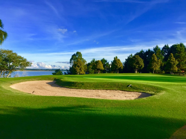 an empty green on the side of a golf course