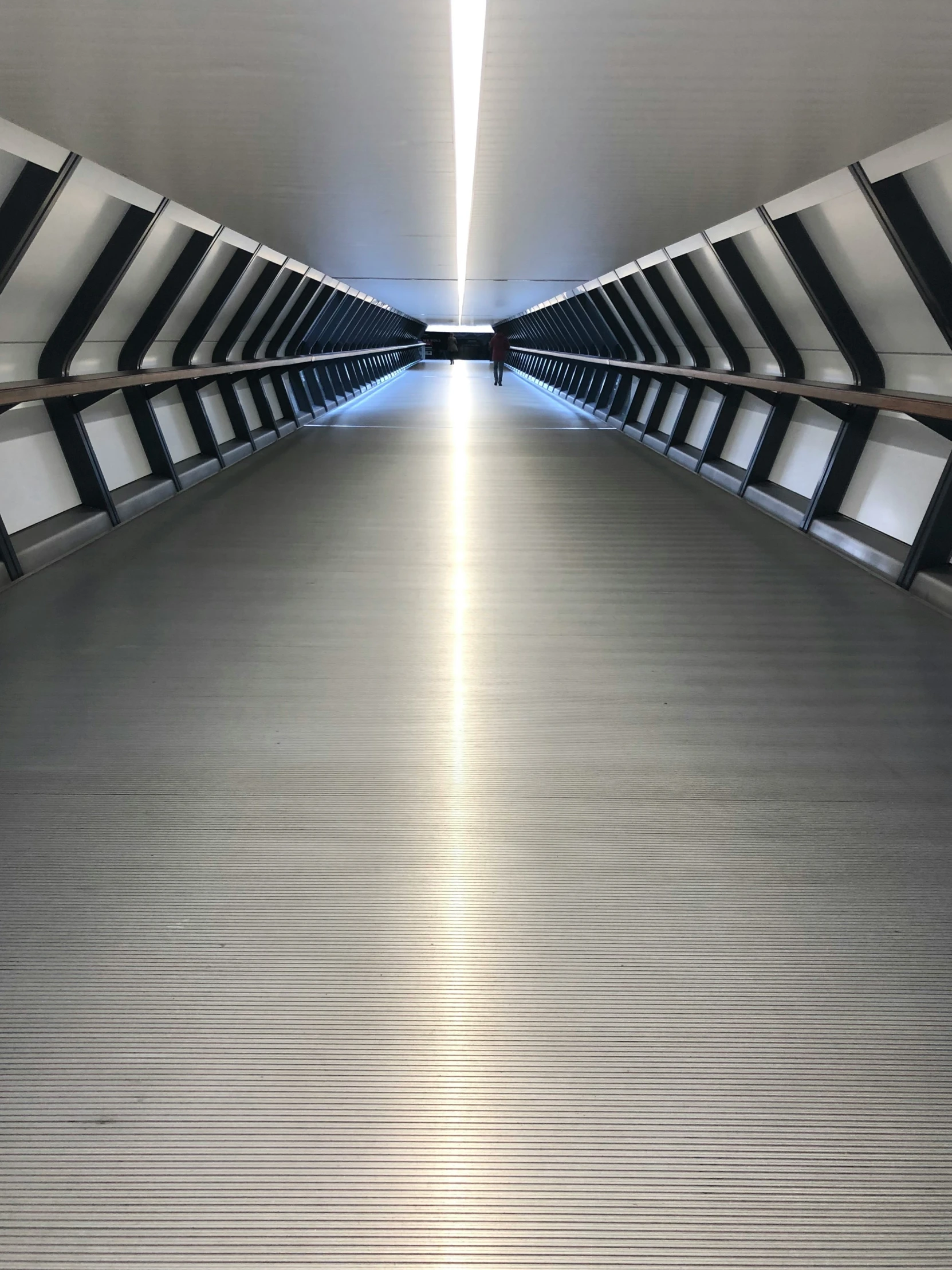 an empty white walkway with bars on it