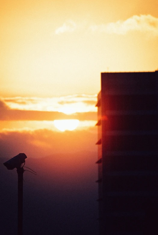 the sun setting over a very tall building