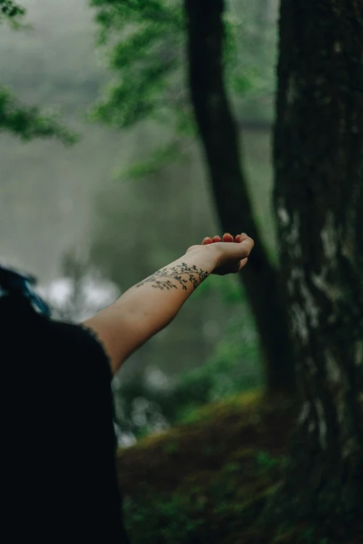 person looking at their hand with tattoo on it