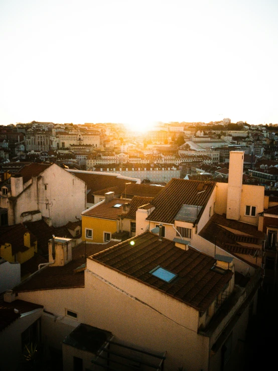 a view of the rooftops of some houses at sunset