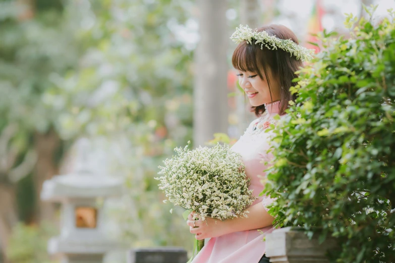 a woman is standing outside and holding some flowers