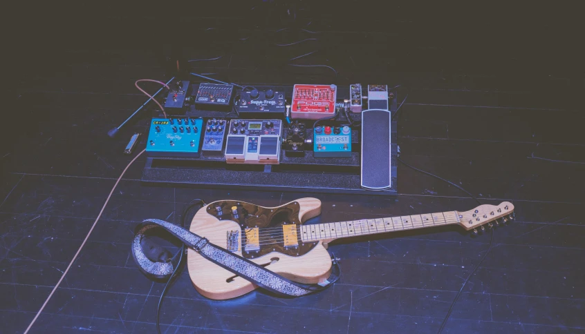 an old guitar is laying on the ground beside a amp