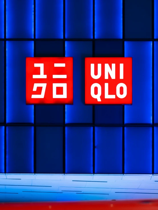 two red signs over a red counter in front of blue wall