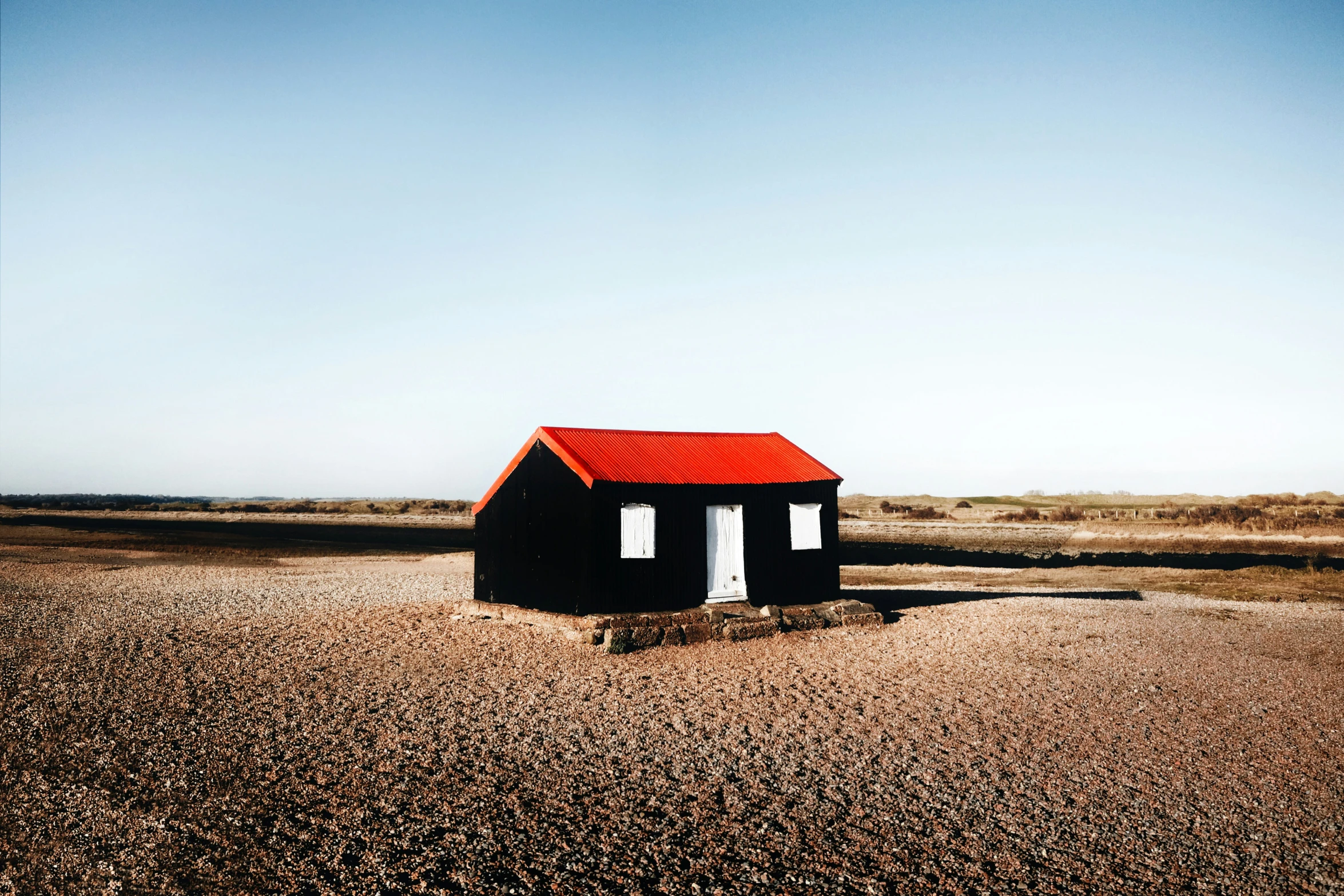 a small barn sitting on top of a desert