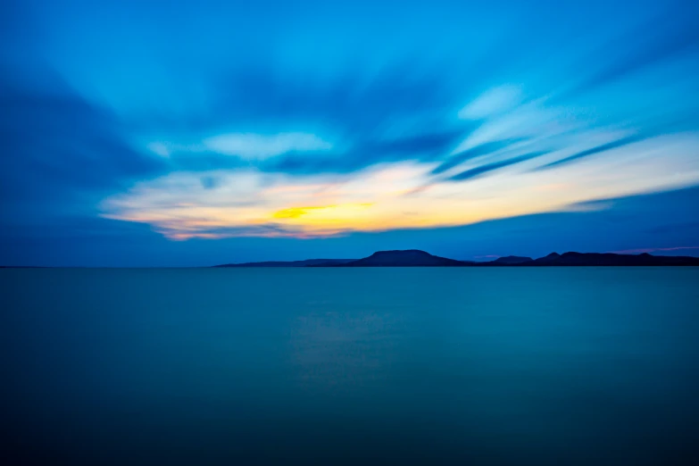 a bright blue sky is reflecting the sun in the ocean