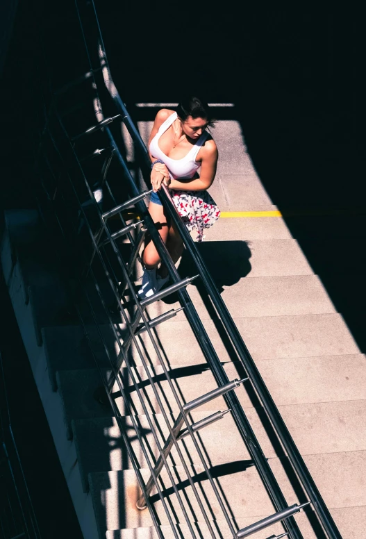 a woman sitting down next to an area with steps and railing