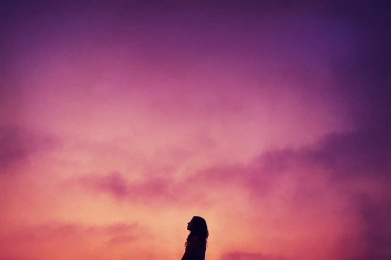 a person is standing on top of a tower at sunset