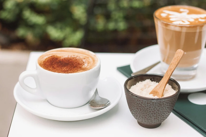 two cups on a table with a spoon