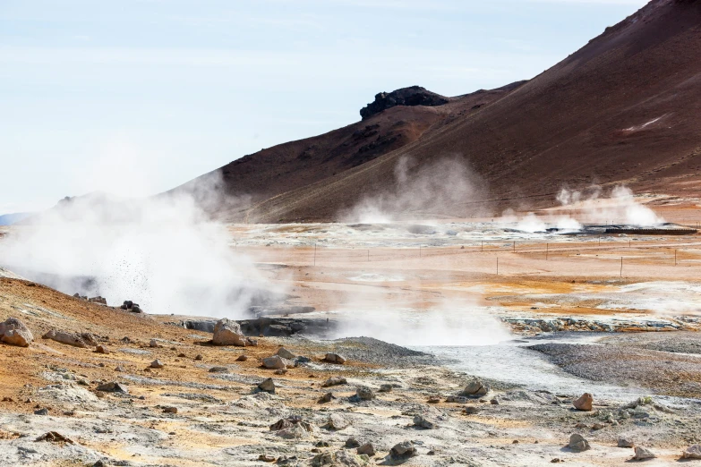 steam rises from a large geomazing area surrounded by mountains