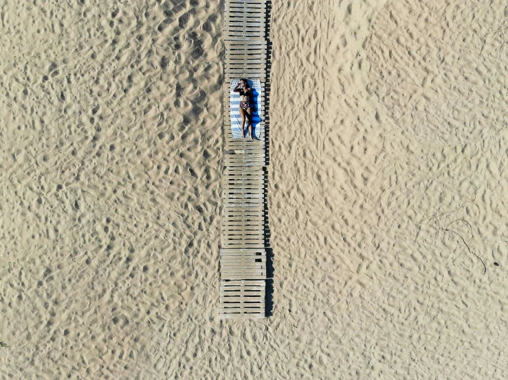 two people standing at a wooden walkway near water