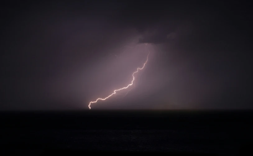 the lightning was striking over the ocean on the horizon