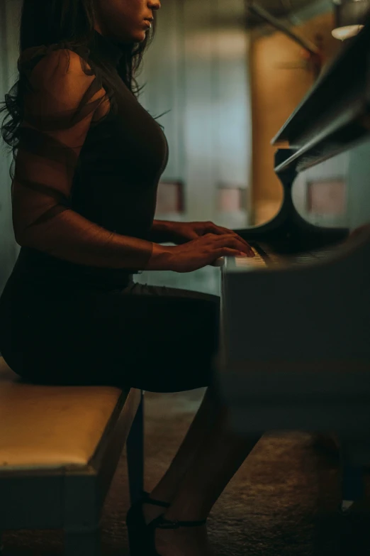 a woman wearing black and playing a piano