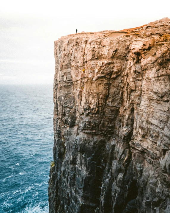 there is a cliff that has two sheeps perched on top