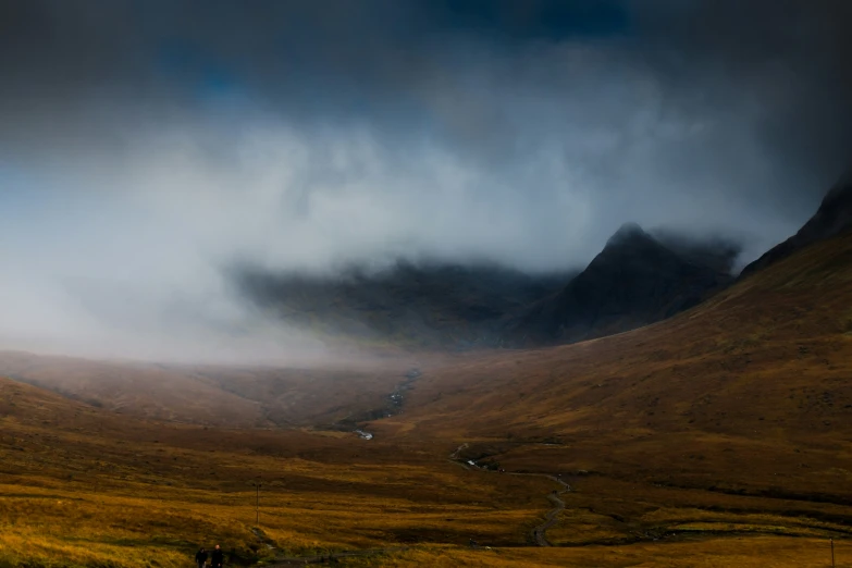 a very big pretty mountain with clouds and mountains in the background