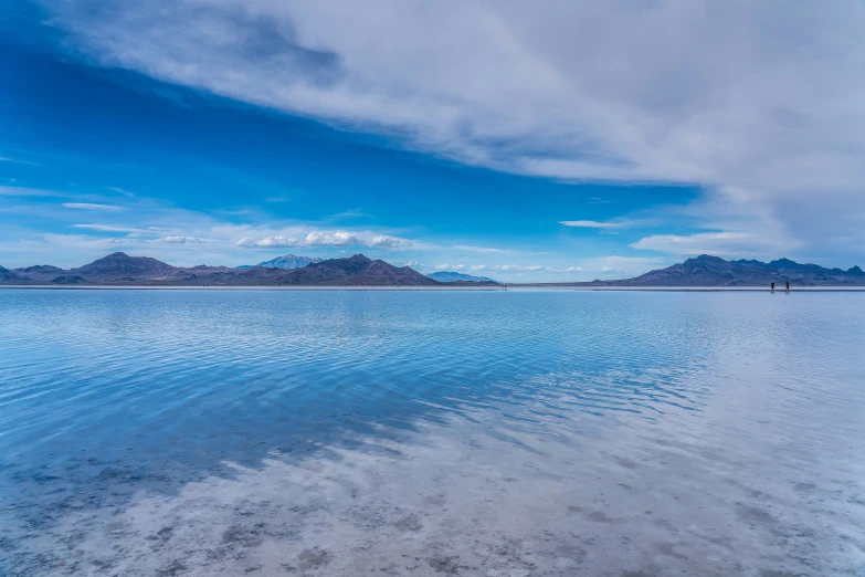 clear blue water with two mountains in the distance